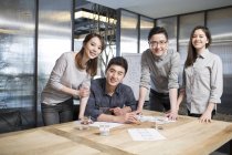 Team of Chinese IT workers posing in office — Stock Photo