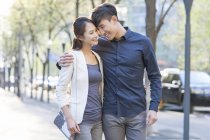 Китайская пара, стоящая на тротуаре в городе лицом к лицу — стоковое фото