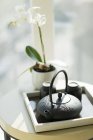 Bule e xícaras de chá na mesa com planta de orquídea — Fotografia de Stock