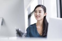 Empresária chinesa sentada no local de trabalho no escritório — Fotografia de Stock