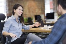 Travailleur informatique féminin montrant le modèle de tablette numérique dans le bureau — Photo de stock