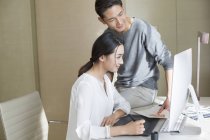 Couple of Chinese illustrators working with drawing tablet together — Stock Photo