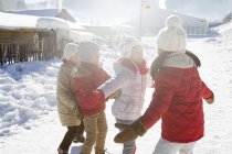Enfants d'âge élémentaire chinois jouant dans la neige au village — Photo de stock