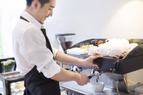 Chino barista haciendo café en la cafetería - foto de stock