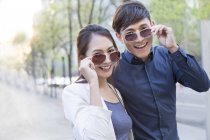 Couple chinois posant avec des lunettes de soleil — Photo de stock