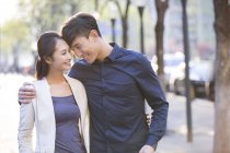 Chinese couple standing on sidewalk in town face to face — Stock Photo