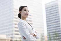 Empresária chinesa olhando para a vista no distrito financeiro — Fotografia de Stock