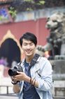 Hombre chino visitando Lama Temple con cámara digital - foto de stock