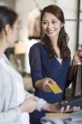 Cliente boutique feminino pagando com cartão de crédito — Fotografia de Stock