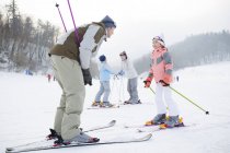 Genitori cinesi che insegnano ai bambini a sciare nella stazione sciistica — Foto stock