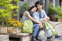 Chinese couple of tourists resting on street — Stock Photo