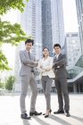 Chinese business people standing on street and looking in camera — Stock Photo