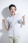 Feliz joven chino escuchando música - foto de stock