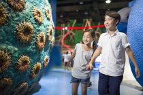 Chinese children looking at exhibition in museum — Stock Photo