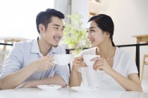 Coppia cinese seduta con tazze di caffè nel caffè — Foto stock