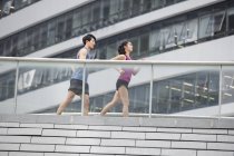 Chinese couple running together on footbridge — Stock Photo