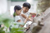 Chinese children using magnifying glass in museum of natural history — Stock Photo