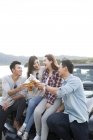 Amigos chineses sentados no carro com cerveja — Fotografia de Stock