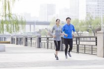 China pareja madura corriendo en la ciudad - foto de stock
