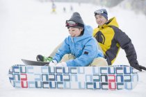 Couple chinois portant des snowboards sur neige — Photo de stock