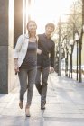 Chinese couple holding hands while walking on sidewalk — Stock Photo