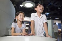 Chinese children sitting at table in museum — Stock Photo