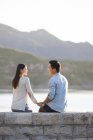 Китайская пара, сидящая на берегу озера в пригороде — стоковое фото