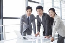 Chinese business people standing in board room — Stock Photo