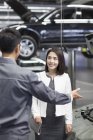 Chino mecánico de automóviles hablando con el propietario del coche - foto de stock