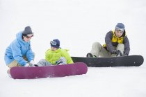Parents chinois portant des vêtements de snowboard sur le fils — Photo de stock