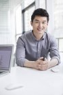 Китайський бізнесмен, сидячи за столом з руки — стокове фото