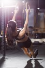 Женщина, занимающаяся гимнастическими кольцами в тренажерном зале — стоковое фото