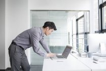 Empresário chinês usando laptop no escritório — Fotografia de Stock