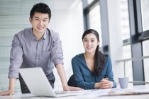 Chinese business co-workers at workplace looking in camera — Stock Photo