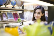 Chinese woman buying souvenirs in gift shop — Stock Photo
