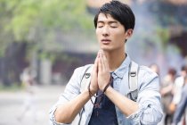 Chinese man praying in the Lama Temple — Stock Photo