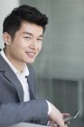 Retrato de hombre de negocios chino con smartphone - foto de stock