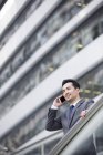 Uomo d'affari cinese che parla al telefono per strada — Foto stock