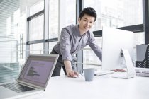 Uomo d'affari cinese che utilizza il computer in ufficio — Foto stock