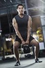 Chinois homme formation avec kettlebell dans Crossfit gymnase — Photo de stock