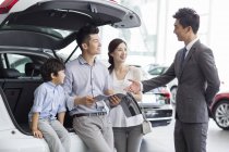 Famille chinoise avec fils choisissant une voiture avec concessionnaire — Photo de stock