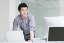 Uomo d'affari cinese che utilizza laptop in ufficio — Foto stock
