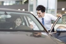 Cinese donna prendendo test drive con auto concessionario assistenza — Foto stock