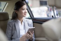 Mujer china sosteniendo smartphone en coche - foto de stock