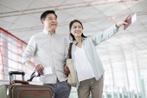 Casal chinês maduro de pé no aeroporto com bilhetes — Fotografia de Stock