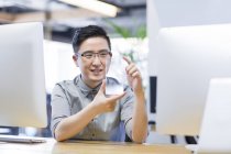 Chinese IT worker developing smartphone in office — Stock Photo