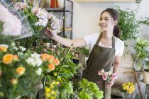 Жіночий азіатський флорист, що працює в квітковому магазині — стокове фото