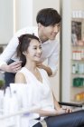 Chinese hairdresser talking with female customer — Stock Photo