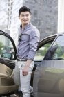 Hombre chino saliendo del coche - foto de stock