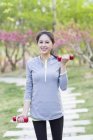 Femme chinoise mature faisant de l'exercice avec haltères dans le parc — Photo de stock